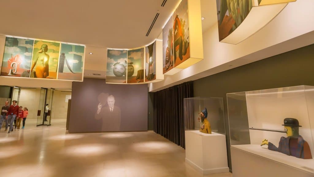 Visiteurs à l'intérieur du hall du musée René Magritte avec 200 peintures, œuvres d'art et sculptures originales.