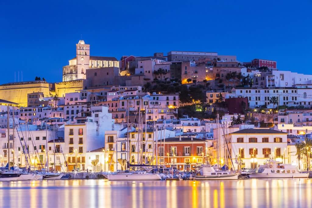 Centre ville d'Ibiza Dalt Vila la nuit avec des reflets lumineux dans l'eau, Ibiza, Espagne.
